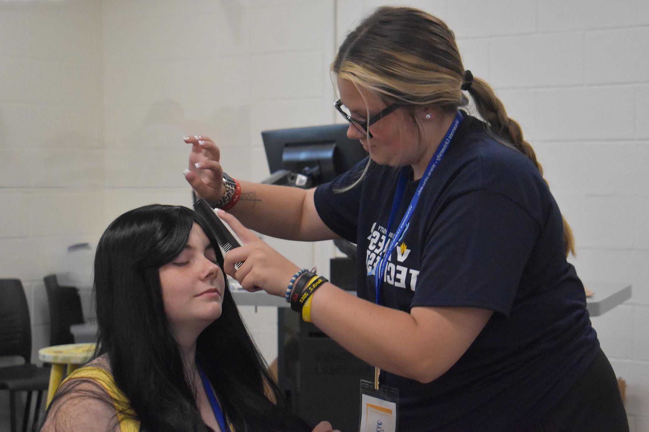 Cosmetology student styling a women's hair